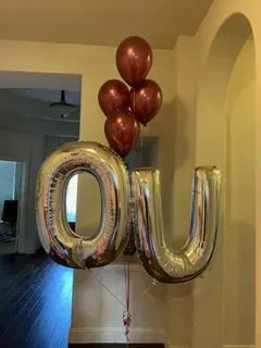 A bunch of balloons in the shape of the letter o and u.