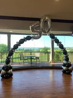 A room filled with balloons and a number 50 balloon.