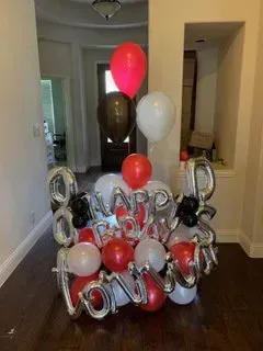 A bunch of balloons are sitting on the floor in a room.
