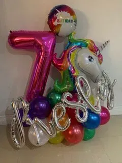 A bunch of balloons with a unicorn and the number 7 on them.