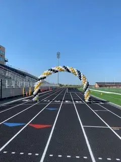 A track with a balloon arch in the middle of it.
