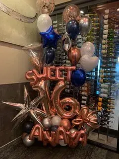 A bunch of balloons are sitting on a table in a room.