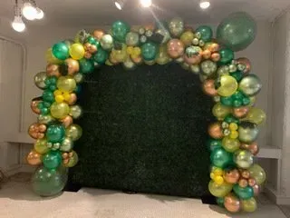 A room filled with balloons and a green wall.