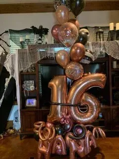 A bunch of balloons are sitting on a table in a living room.