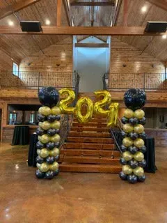 A room filled with balloons and a staircase with balloons in the shape of the year 2021.