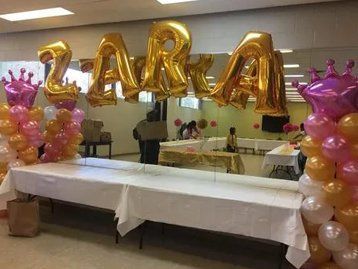 A room filled with balloons and a table with the name zara on it.