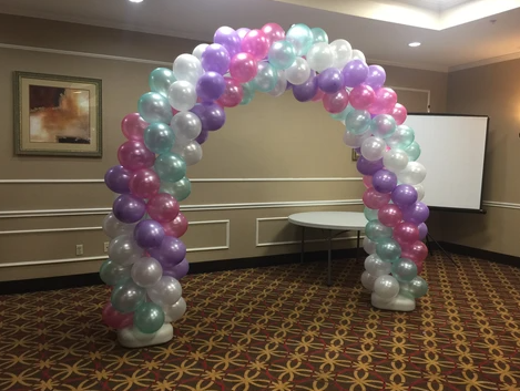 A room with a balloon arch in the middle of it.