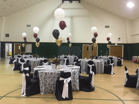 A large room with tables and chairs set up for a party