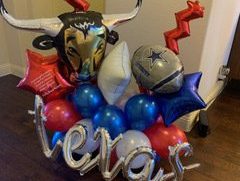 A bouquet of red , white , and blue balloons with a bull head in the middle.