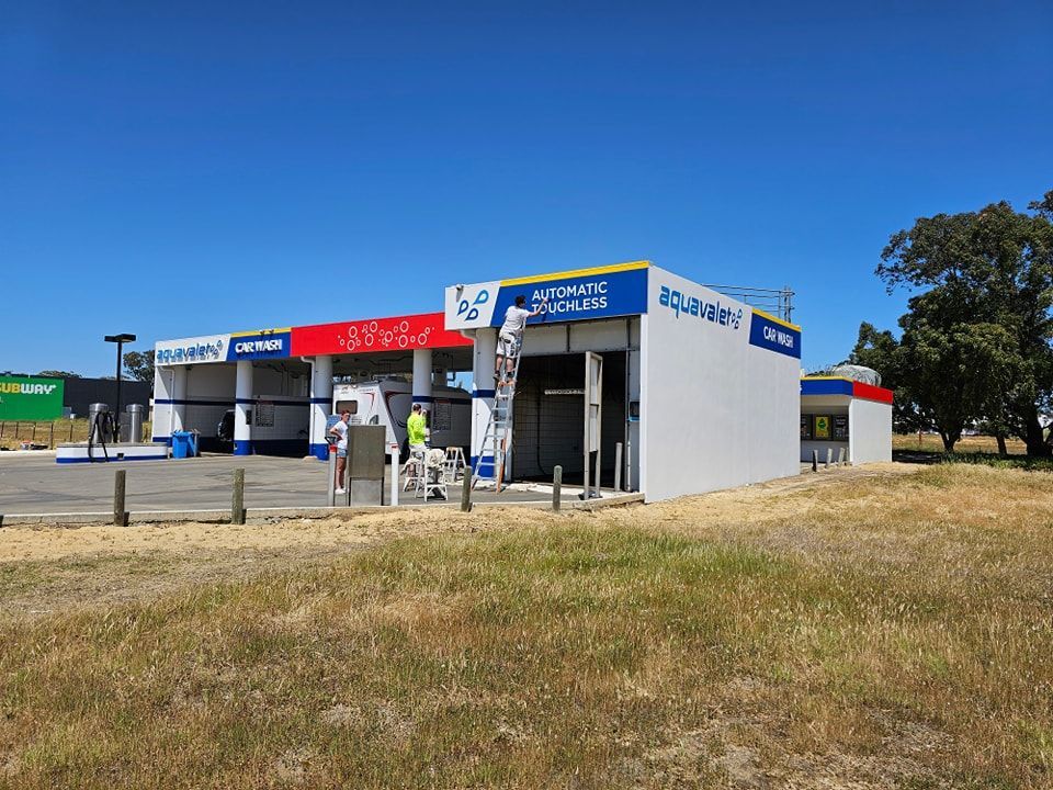 A car wash is being painted in a field.