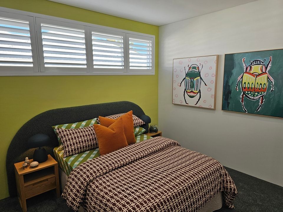 A bedroom with a bed and two paintings on the wall
