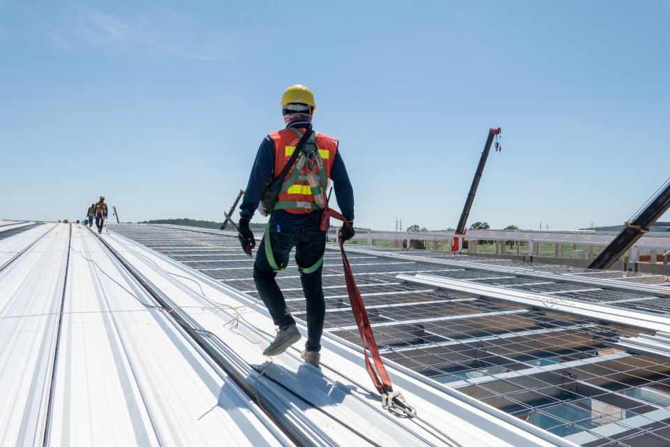 a construction worker is walking on the roof of a building.