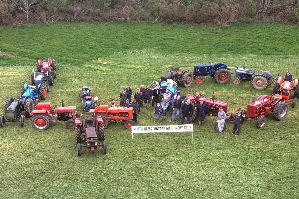 A group of tractors are parked in a grassy field.