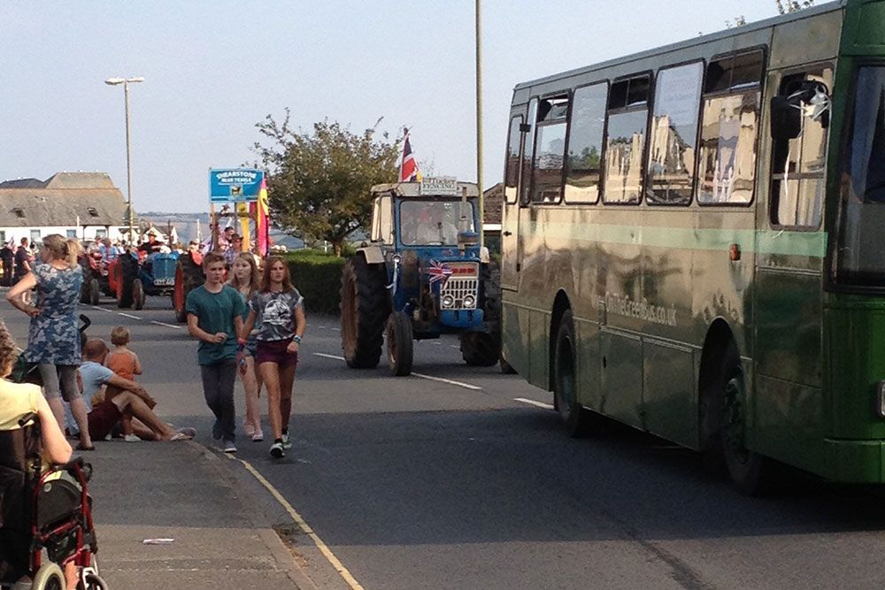 A group of people walking down a street next to a bus