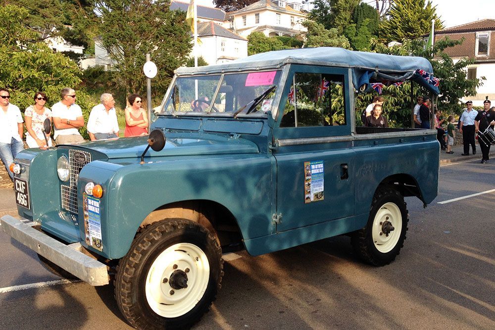 A blue land rover is parked on the side of the road