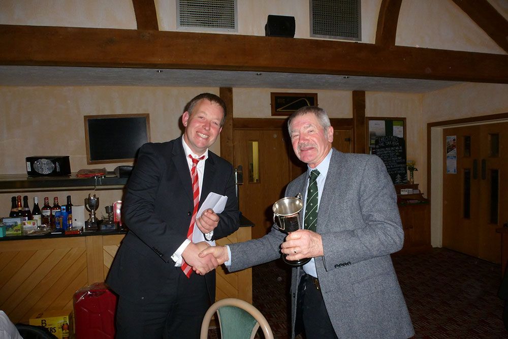 A man in a suit and tie shakes hands with another man
