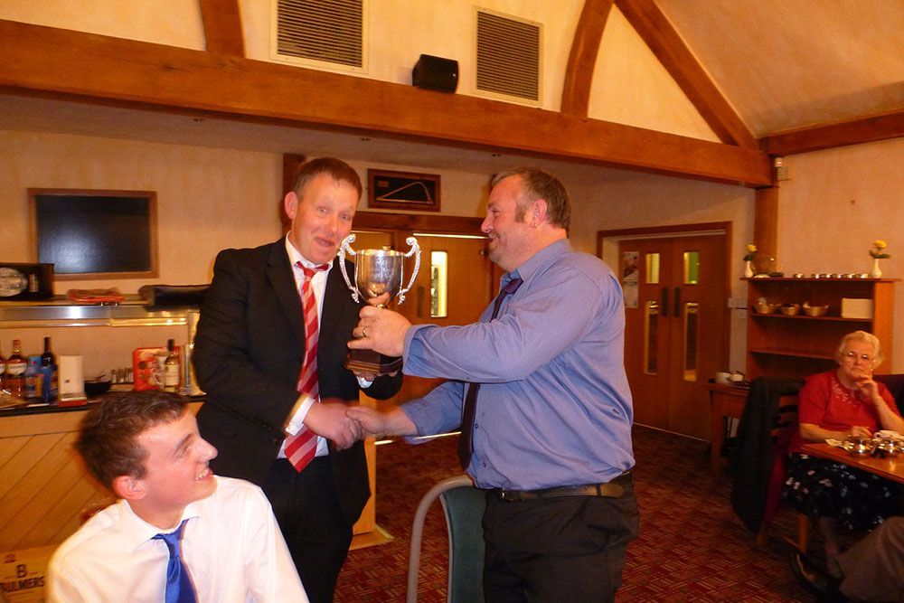 A man in a suit and tie is shaking hands with another man