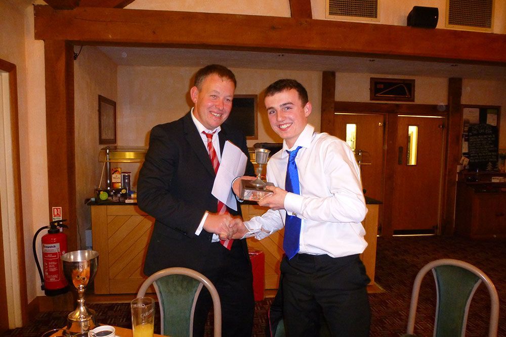 A man in a suit and tie is shaking hands with another man