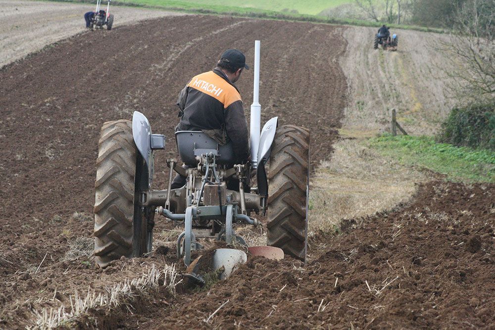 A man is plowing a field with a tractor.