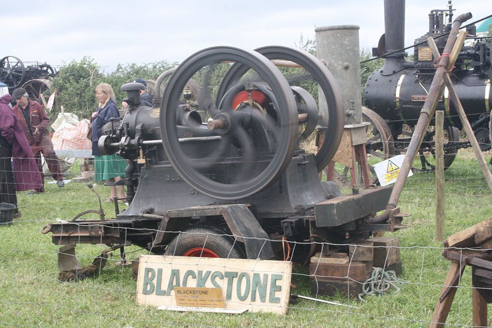 An old blackstone engine is sitting in the grass