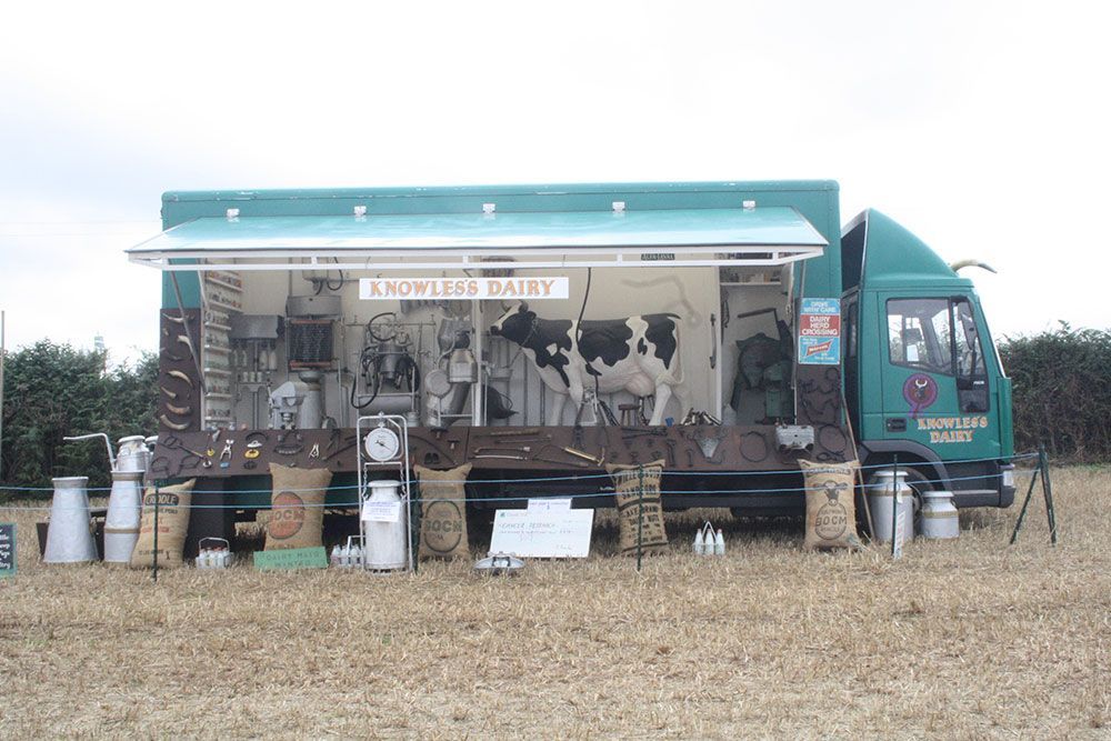 A green truck with a sign that says knowledge dairy