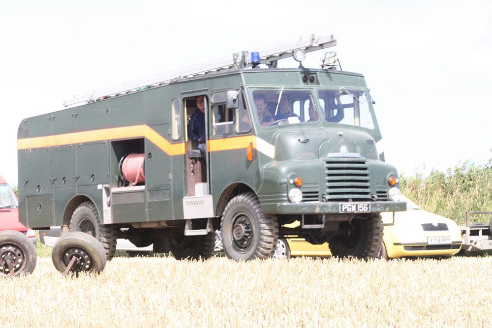A green and yellow truck is parked in a field.