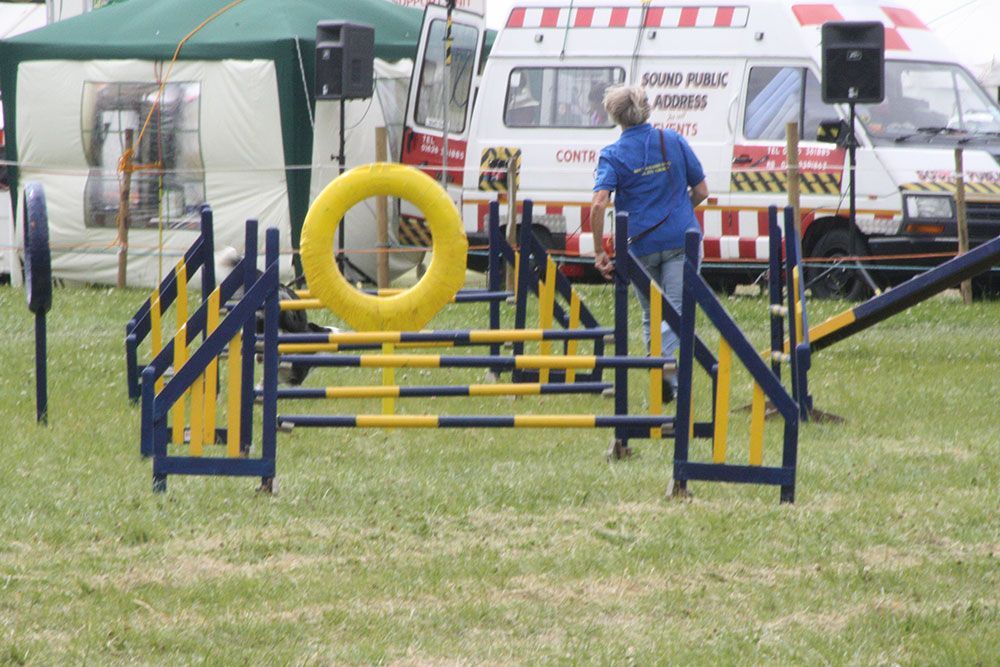 A man in a blue shirt stands in front of a white van that says ambulance