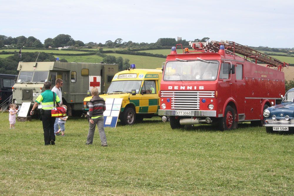 A red bennis fire truck is parked next to an ambulance