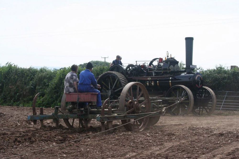 A group of people are riding on a tractor in a field.