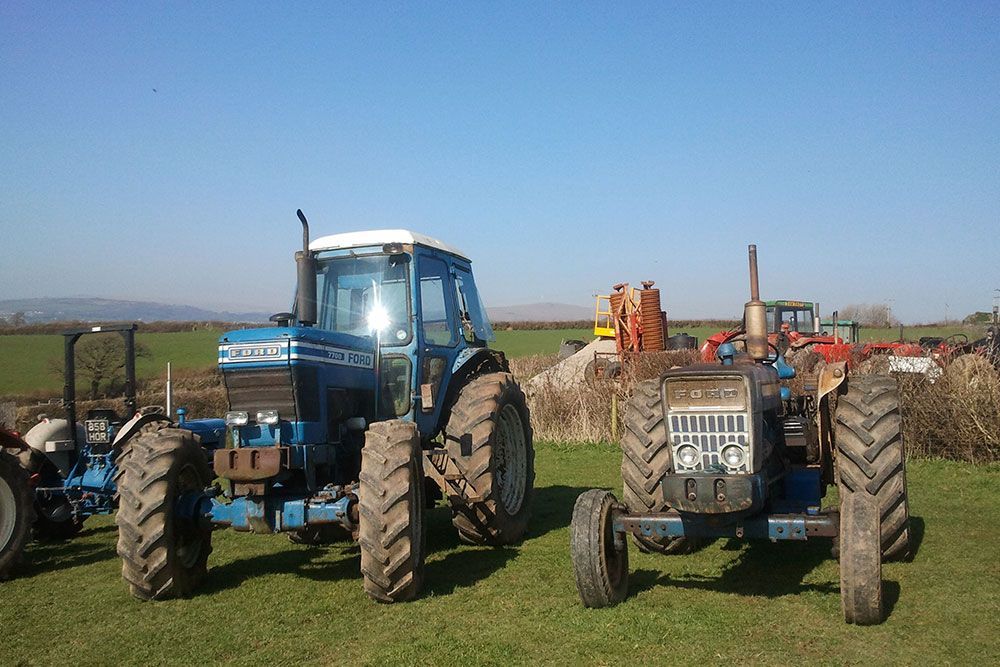 A ford tractor is parked next to another tractor