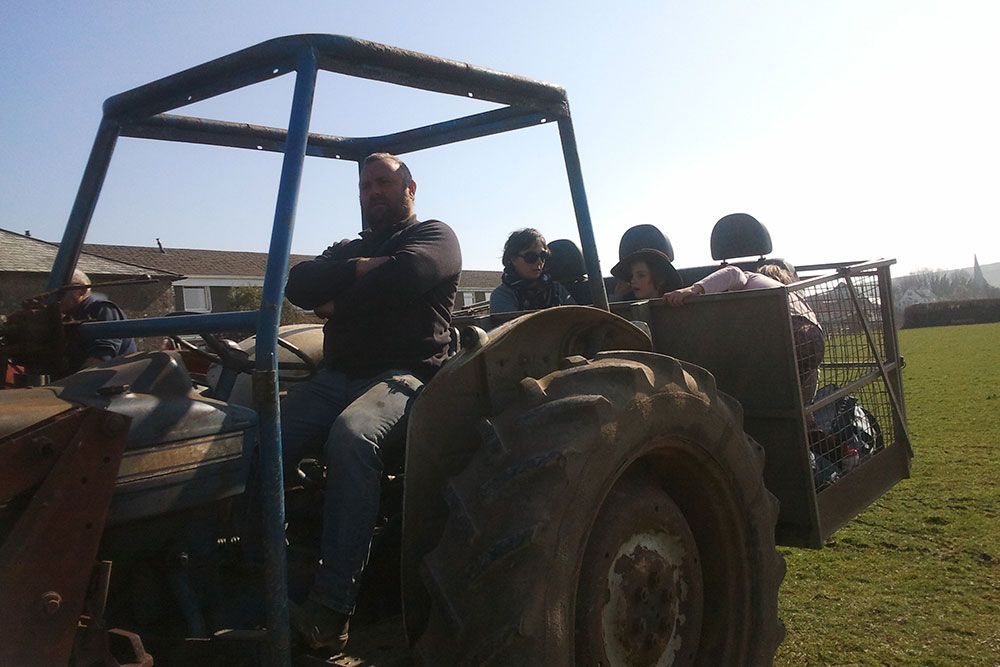 A group of people are sitting on a tractor in a field