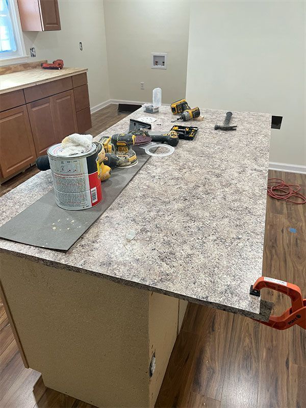 Kitchen island with speckled countertop and tools.