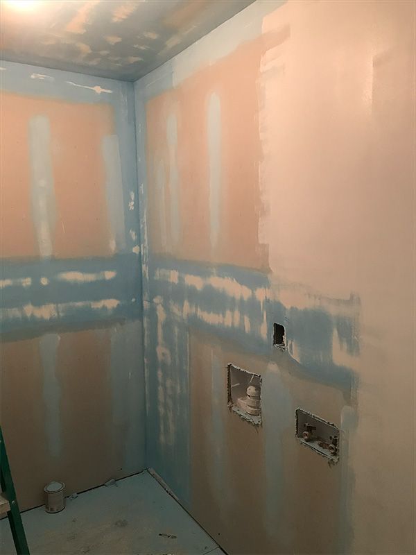 Room with blue and pink unfinished walls. Electrical outlets visible.