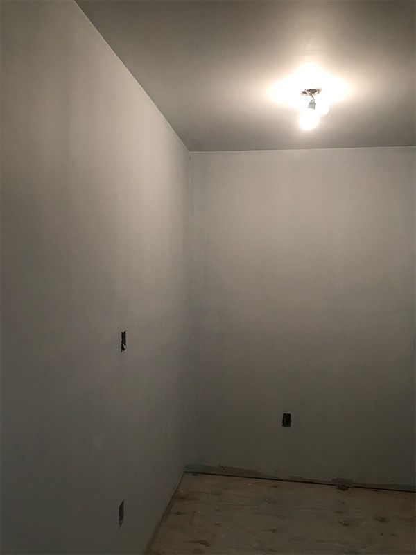 Empty room with light fixture. White walls and ceiling. 