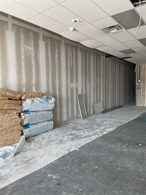 Construction site interior; drywall, insulation, and unfinished floor.