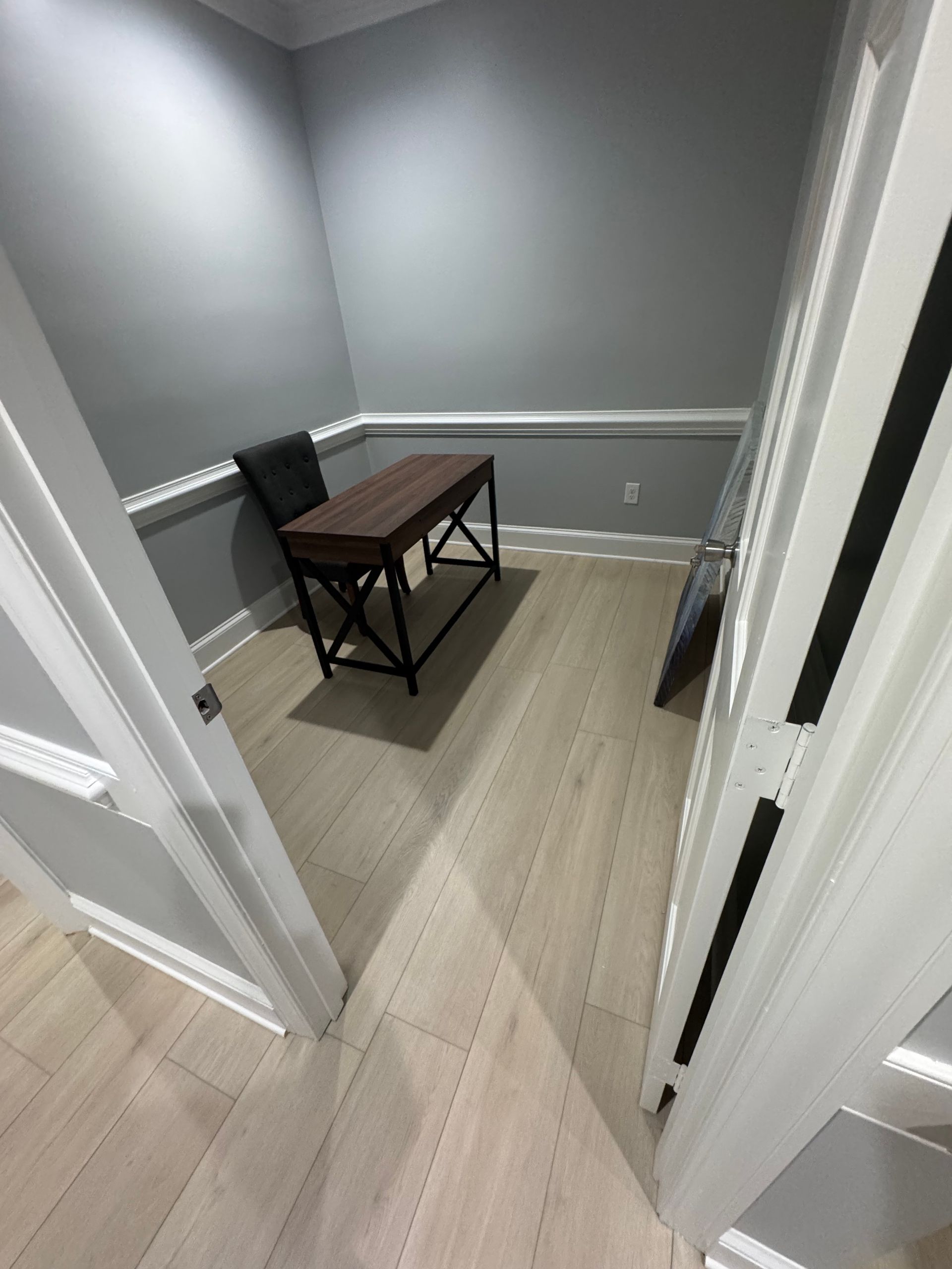Living room with gray sofa, art, wood furniture, yellow chair, and beige walls.