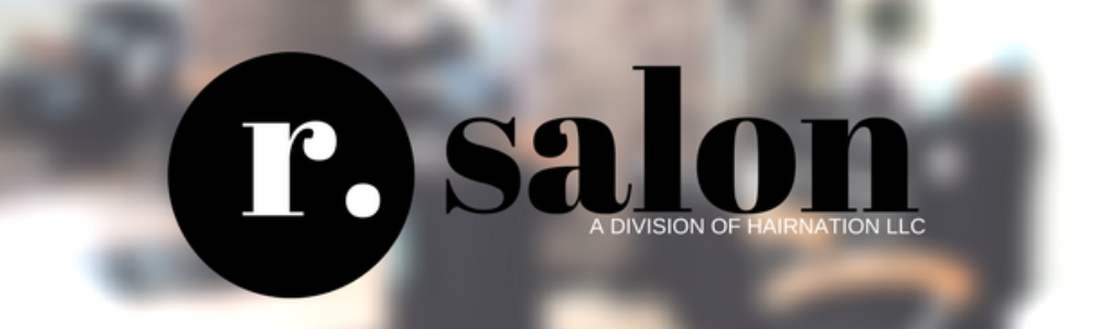 a black and white logo for r. salon with a blurry background