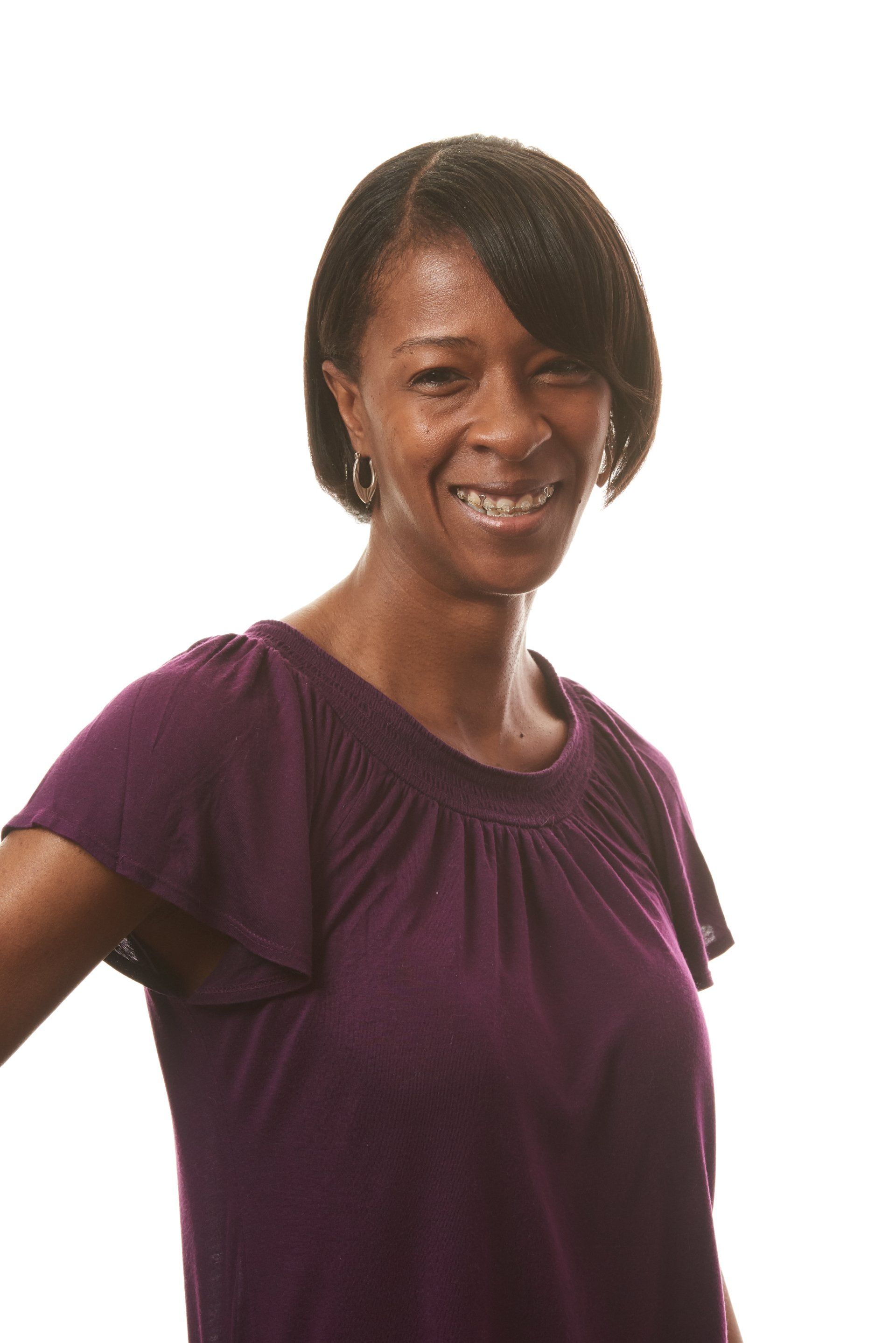 A woman in a purple shirt is smiling for the camera