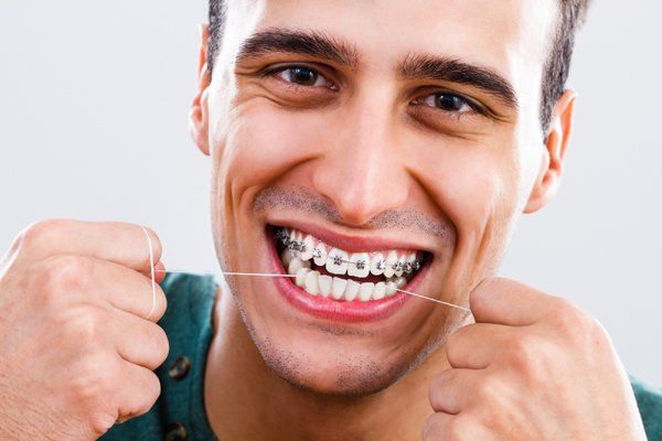 Man using dental floss — Buffalo Grove, IL — Rosen Orthodontics