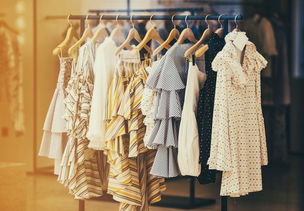 A row of dresses hanging on a rack in a store.