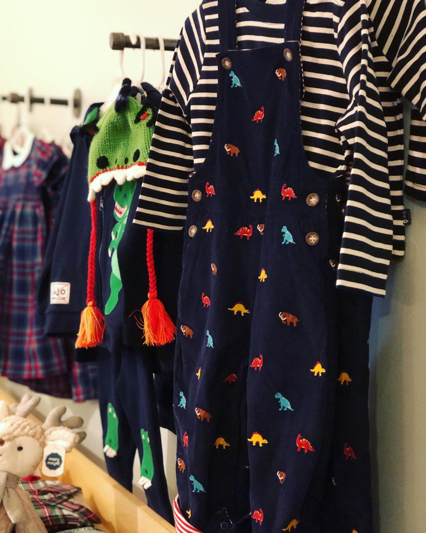 A row of children 's clothes are hanging on a rack