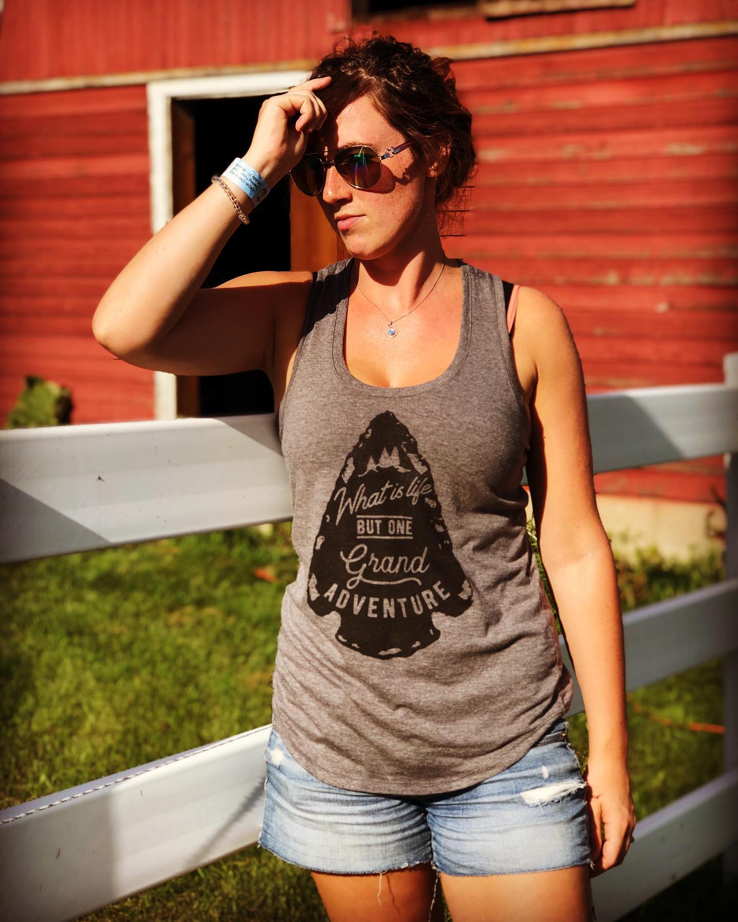 A woman wearing a tank top that says grand adventure