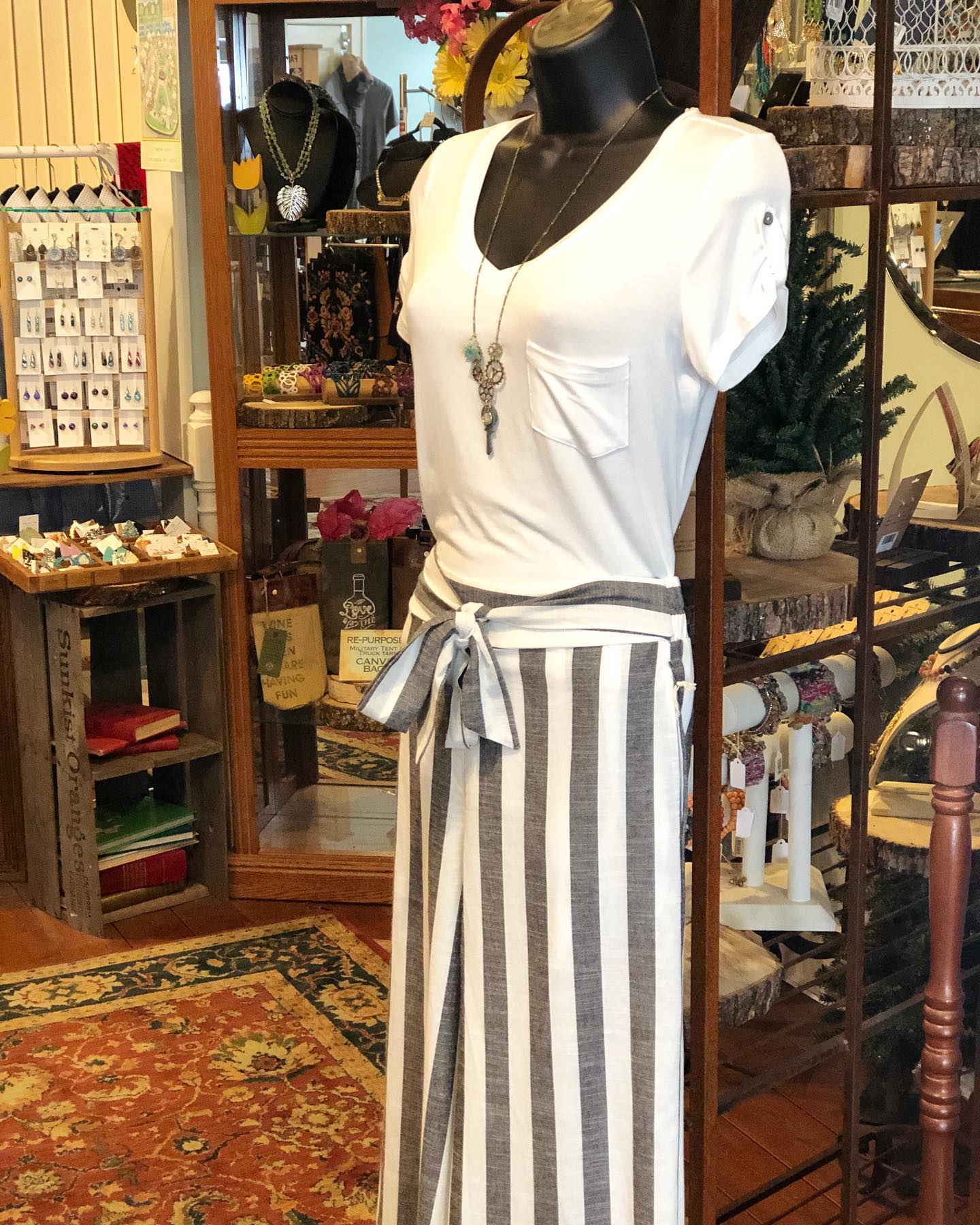 A mannequin is wearing a white shirt and striped pants