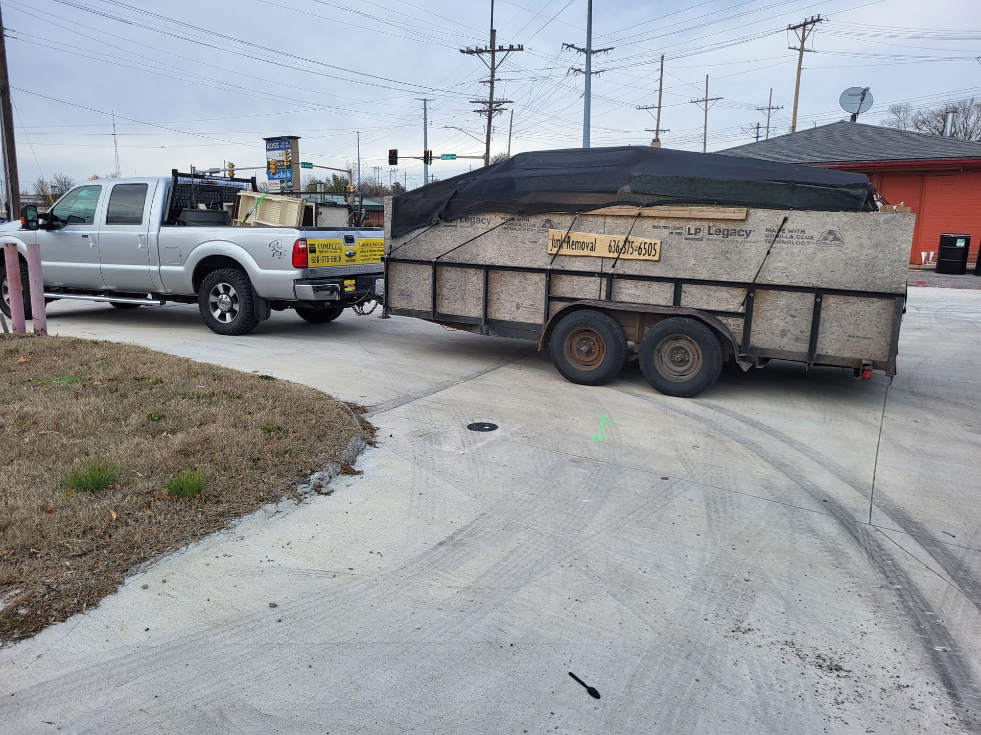 A truck is towing a trailer on a street.