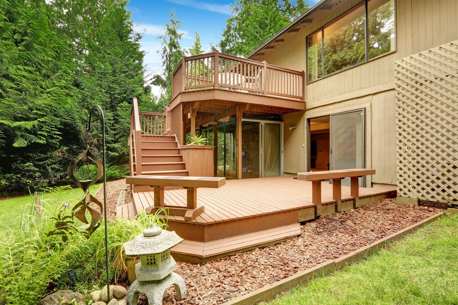 The backyard of a house with a large deck and stairs.