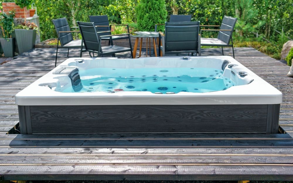 A hot tub is sitting on top of a wooden deck.