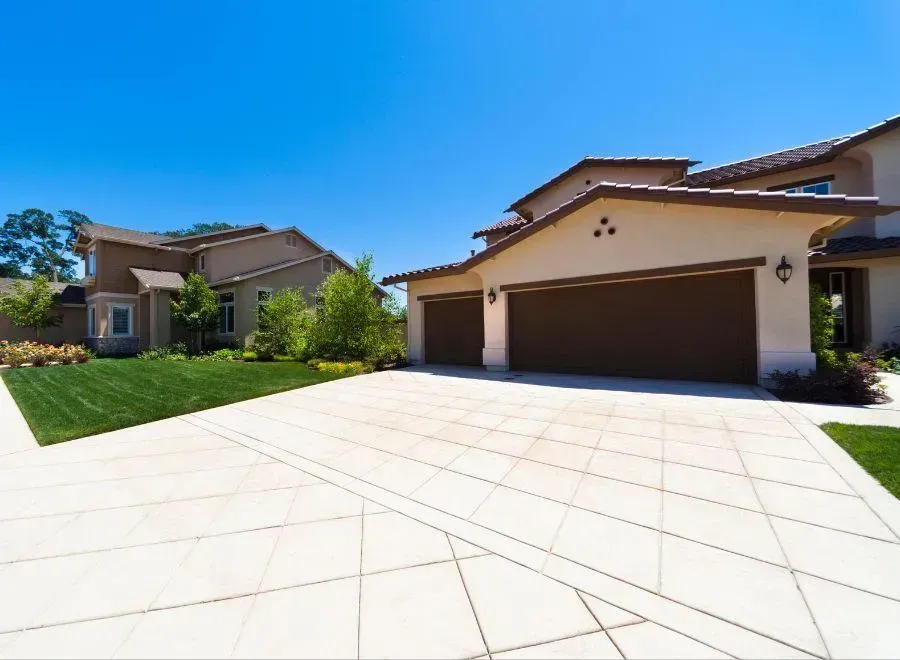 Elite Outdoor Living Solutions installed a custom concrete driveway for a two-story house in Norman, OK.