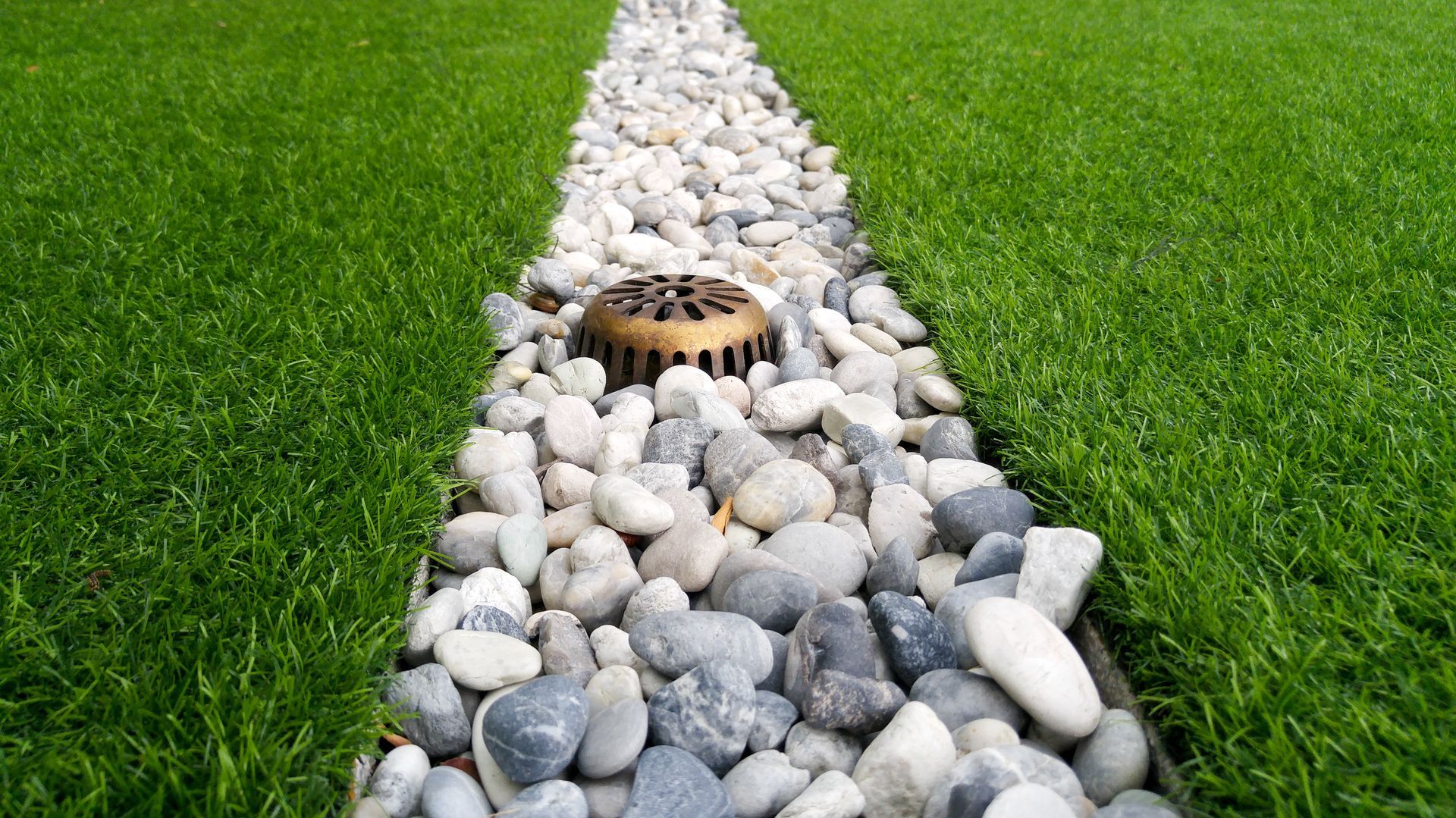 Elite Outdoor Living Solutions is installing a functional rock-lined surface drain in Quail Creek, OKC.