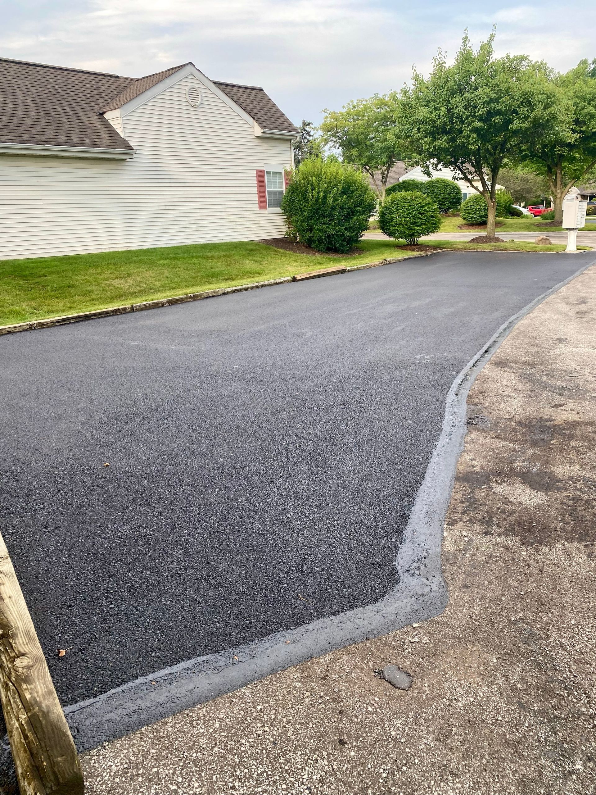 A newly paved driveway in front of a house.