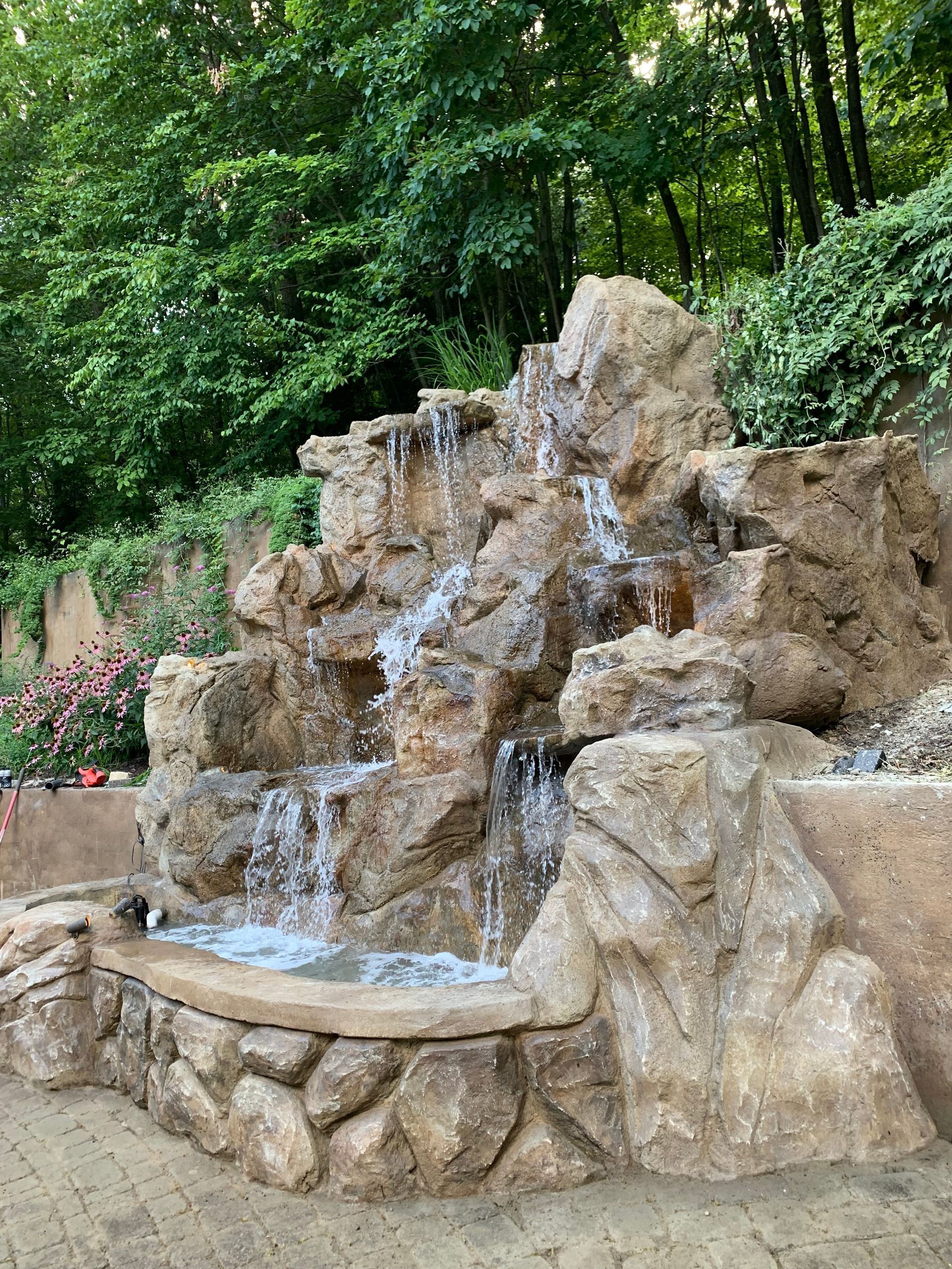 Elite Outdoor Living Solutions is installing a custom swimming pool with a waterfall in Oklahoma City.